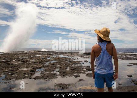 Man wearing straw hat and beach cloths, staring at waves, Samoa Stock Photo