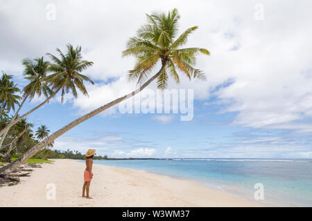 Man wearing blue singlet and shorts, staring at blowholes and ocean Stock Photo