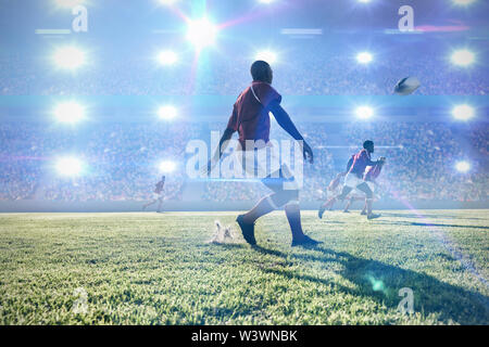 Composite image of rugby player kicking the ball to teammates on field. Stock Photo