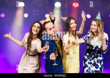 party, holidays, celebration, nightlife and people concept - smiling friends with glasses of champagne in club. Stock Photo