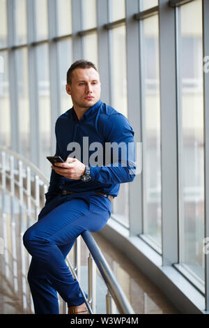 Young businessman with mobilephone in the airport lounge. Stock Photo