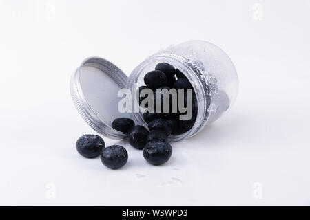 A jar full of cold blueberries - Cold and sweet isolated blueberries on a white background - Close-up Stock Photo
