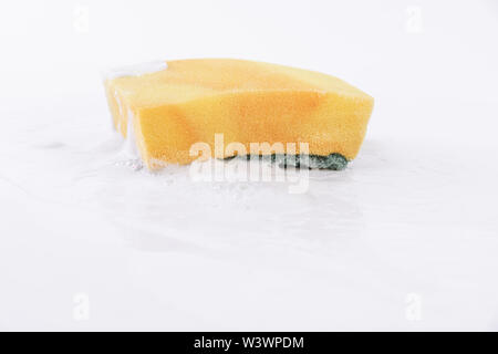 Dish-washing sponge with detergent and foam on white background Stock Photo