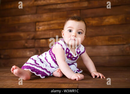 Cute little girl on a wooden background. Stock Photo