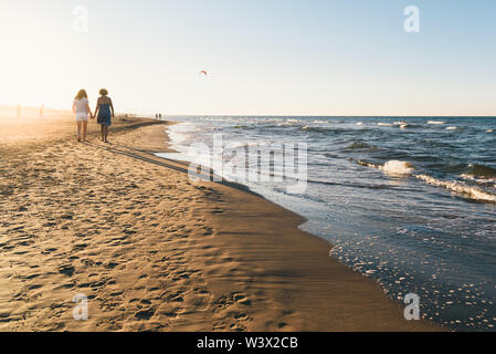 Happy Mother and Daughter Enjoying Beautiful Sunset Walk on the Beach. Travel Vacation Lifestyle Concept Stock Photo