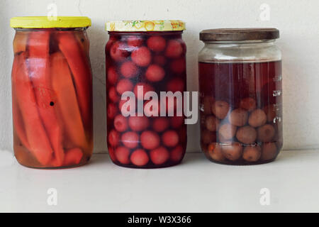 Variety of preserved food in glass jars - jam, marmalade, cherries, red pepper Preserving vegetables and fruits. Fermented food. Autumn canning Stock Photo