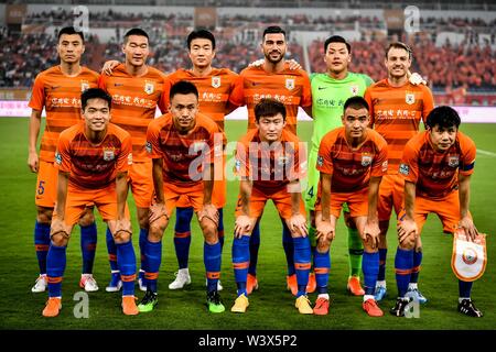 Players of the starting line-up of Shandong Luneng Taishan pose for photos before competing against Tianjin Tianhai in their 18th round match during the 2019 Chinese Football Association Super League (CSL) in Ji'nan city, east China's Shandong province, 17 July 2019. Shandong Luneng Taishan defeated Tianjin Tianhai 2-1. Stock Photo