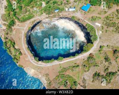 Aerial drone top view of Broken Beach In Nusa Penida, Bali, Indonesia. Overhead View Of Rocky Coast And Coves Stock Photo