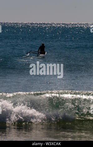 A young woman paddles out into the Coral Sea in her kayak for an early morning exercise from Agnes Water Beach at Agnes Water in Queensland, Australi Stock Photo