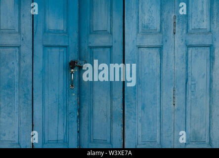 Closed blue wooden door. Vintage front door abstract background. Abandoned old house. Old wooden door texture. Lock the door of old home. Exterior Stock Photo