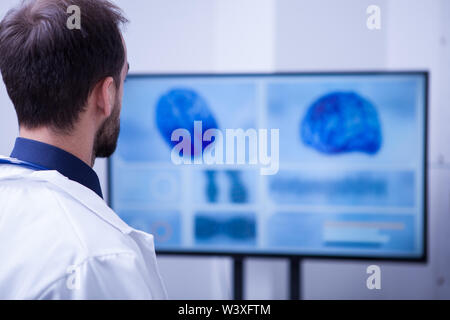 Young male doctor checking his patient brain after surgery. Doctor in hospital. Stock Photo