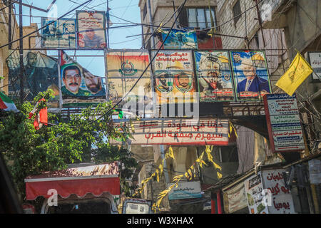 Beirut Lebanon. 18th July 2019. Pictures of Yasser Arafat and Palestinian president Mahmood Abbas hang at the entrance to Sabra refugee camp housing thousands of Palestinian refugees in Beirut. Palestinians in Lebanon have protested against a government crackdown on unlicensed workers and cheap labour and on businesses hiring foreign workers without permit Credit: amer ghazzal/Alamy Live News Stock Photo