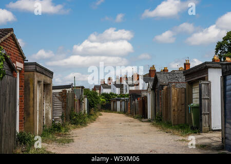 A back street view of a row of small Victorian terraced houses with garages Stock Photo