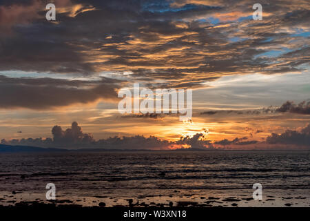 Amazing Sunset/Sunrise view with dramatic clouds in sky, at coastal region of exotic tropical island Dispersion of light according to color wavelength Stock Photo