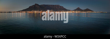 The city lights of Cape Town reflect in the waters of Table Bay in a panoramic photo taken from a ship in the Atlantic Ocean. Stock Photo