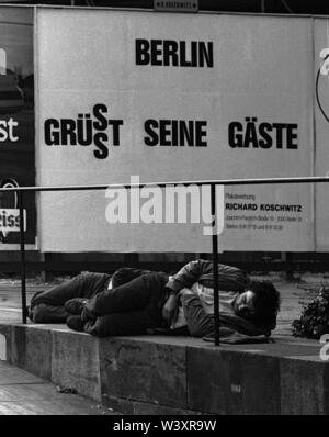 FILED - 01 January 1980, Berlin: Berlin districts/Charlottenburg/1980 Homeless people at the Gedaechtniskirche. Behind it an advertising poster of Berlin // Poverty/Social/Advertising/Housing Photo: Paul Glaser/dpa-Zentralbild/ZB Stock Photo