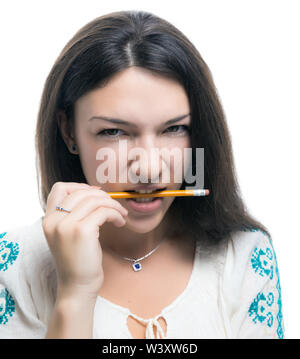 Young woman holding a pencil in her teeth on white background. Stock Photo