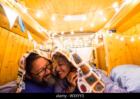 Couple in love and relationship have fun during a travel vacation with an old restored van to tiny house - van life concept for modern trendy people e Stock Photo