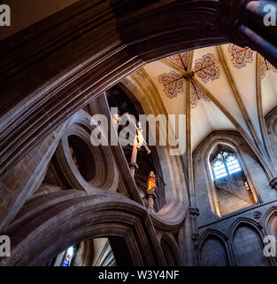 Looking up at the scissor or St Andrews Cross arches facing the nave of Wells cathedral in Somerset UK with Christ crucified looking down Stock Photo