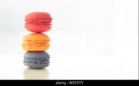 Macarons pastel colors stacked on white background, close up view with details, copy space Stock Photo