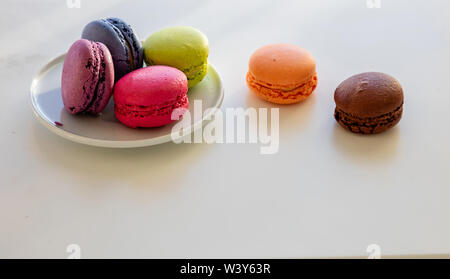 Macarons pastel colors in a plate on white background, close up view with details, copy space Stock Photo