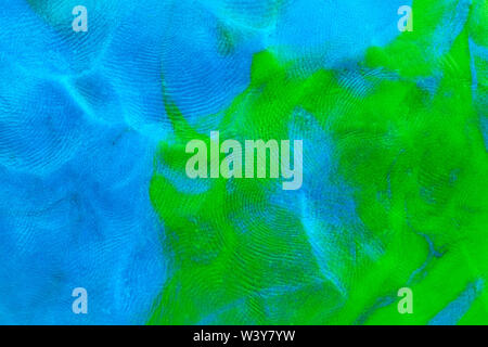 Mixed blue-green flat plasticine texture with distinct fingerprints. Small dust particles on surface. Stock Photo