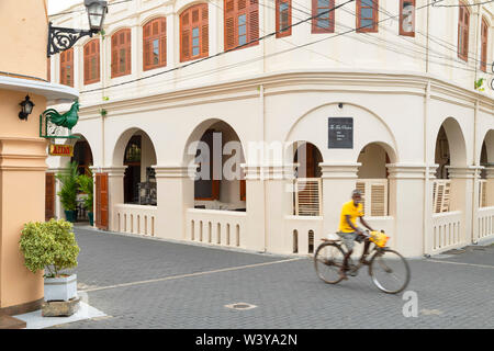 Man cycling past The Fort Printers Hotel, Galle, Southern Province, Sri Lanka Stock Photo