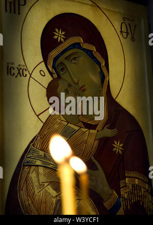 Blurred candle lights against orthodox icon The Virgin and Child Stock Photo