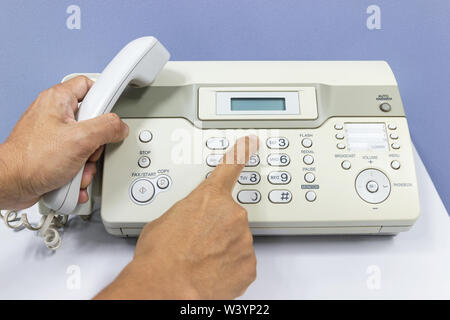 hand man are using a fax machine in the office Business concept Stock Photo