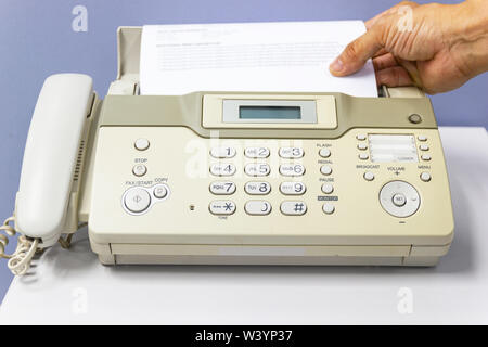 hand man are using a fax machine in the office Business concept Stock Photo