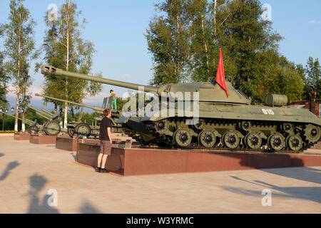 A visitor looks at an old Iosif Stalin battle tank or IS-2 tank, named after the Soviet leader Joseph Stalin displayed at the monument complex to Peter Barbashov Hero of the Soviet Union who sacrificed himself on 9 November 1942 in order to protect his company during the fighting for Vladikavkaz located on the route Vladikavkaz - Alagir, near the village of Gizel in the Republic of North Ossetia-Alania the North Caucasian Federal District of Russia. Stock Photo