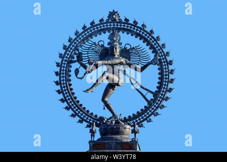Nataraja, depiction of the Hindu god Shiva as the cosmic ecstatic dancer / Lord of the Dance against blue sky Stock Photo