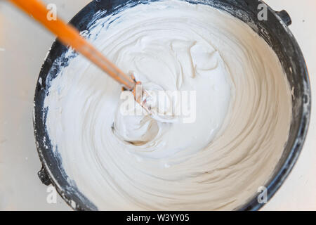 mix plaster with putter mixer in the bucket Stock Photo