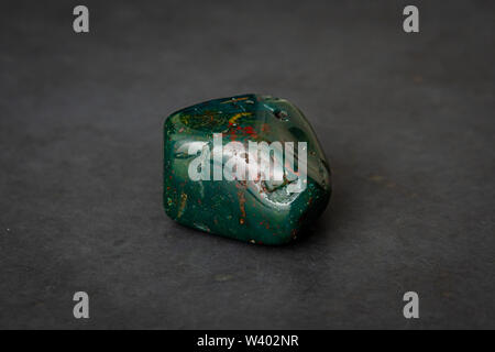 Indian Achat deep green gemstone with red and yellow structures all over it Stock Photo