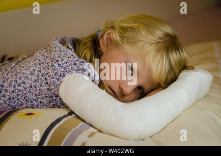 hurt blond girl with broken hand  lying in hand Stock Photo