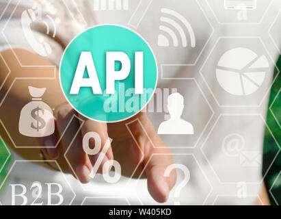 Businesswoman pushes a button API, Application Programming Interface on the touch screen Stock Photo
