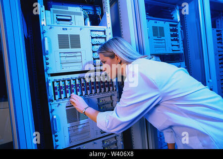 Woman technician working on computer servers Stock Photo