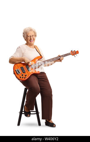 Full length portrait of an elderly female guitarist with an electric bass guitar sitting on a chair isolated on white background Stock Photo
