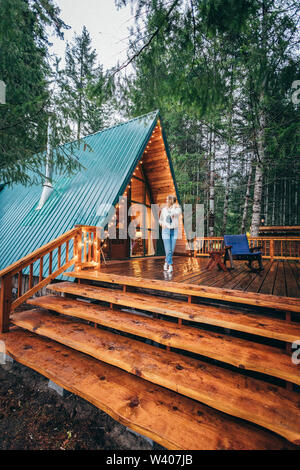 Girl on a deck of beautiful cabin in the woods