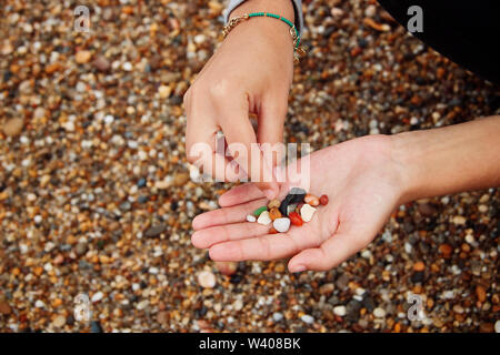 Hand picking some stones on the beach. Stock Photo