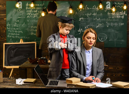 Attentive teacher talking to her student in science class at the university, Good teachers seek engaged students, Hipster is solving math exam, Modern Stock Photo