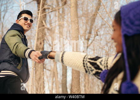 Couple reaching out while hiking in the snow in winter Stock Photo