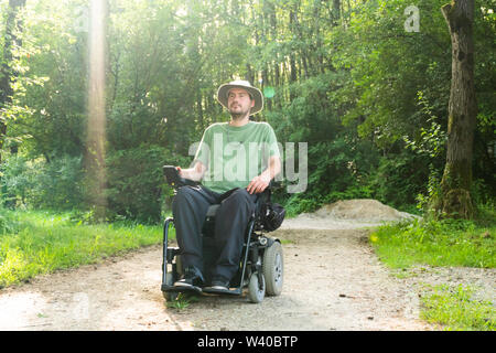 Portrait photo of a handicapped man in a electric wheelchair in nature Stock Photo