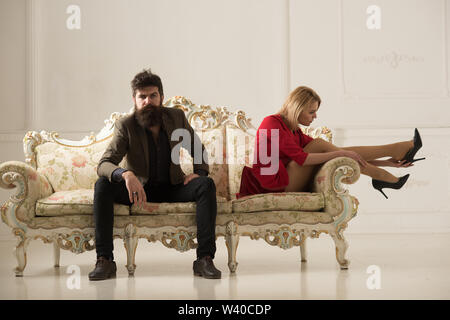 shop assistant. bearded man shop assistant helps woman to choose shoes. shop assistant concept. woman and shop assistant guy on sofa try on new shoes Stock Photo