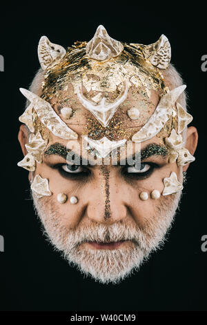 Man with golden reptilian skin and white beard. Monster with sharp thorns and warts on face, horror and fantasy concept. Demon head with evil look on Stock Photo