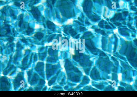 Abstract patterns formed by strong sunlight on the surface of water in a swimming pool  similar to  David Hockney's famous paintings Stock Photo