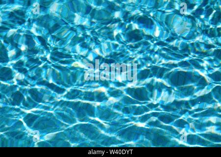 Abstract patterns formed by strong sunlight on the surface of water in a swimming pool  similar to  David Hockney's famous paintings Stock Photo