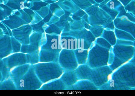 Abstract patterns formed by strong sunlight on the surface of water in a swimming pool  similar to  David Hockney's famous paintings Stock Photo