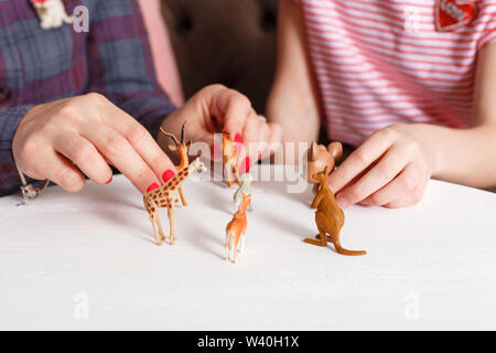 Teen girl on reception at the psychotherapist. Psychotherapy session for children. The psychologist works with the patient. The girl plays toy animals Stock Photo