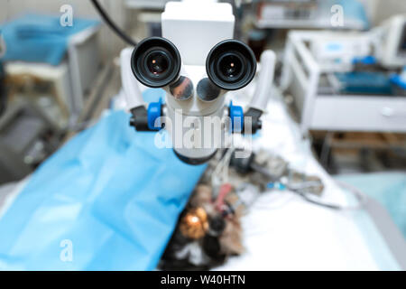 Vet ophthalmologist surgical microscope in operating room. and dog with injured eye on operating table, ready for operation. Stock Photo